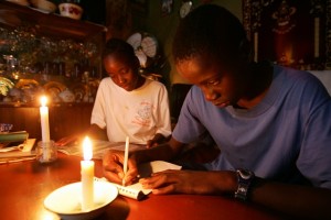 Fourteen-year-old Zimbabwean twins Gugulettu (L) and Ntokozo Ndebele read and write by candlelight at their family home in the capital Harare February 19, 2006. Frequent electricity failures and load shedding plague the country and are the result of ageing generating and distribution equipment and a critical shortage of foreign currency to import the necessary spare parts. Zimbabwe does not produce sufficient electricity for its own needs so it imports power from neighboring South Africa, Mozambique, Zambia and the Democratic Republic of Congo (DRC).  REUTERS/Howard Burditt
